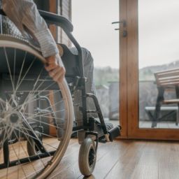 Accesibilidad en la vivienda para favorecer la vida independiente Persona usuaria de silla de ruedas desplazándose por el interior de una vivienda accesible, símbolo de la autonomía personal y la eliminación de barreras arquitectónicas.