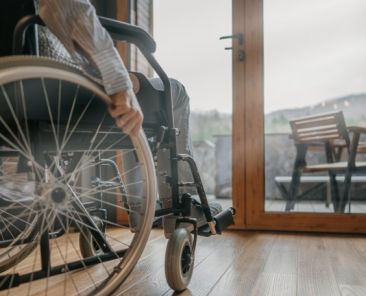 Persona usuaria de silla de ruedas desplazándose por el interior de una vivienda accesible, símbolo de la autonomía personal y la eliminación de barreras arquitectónicas.