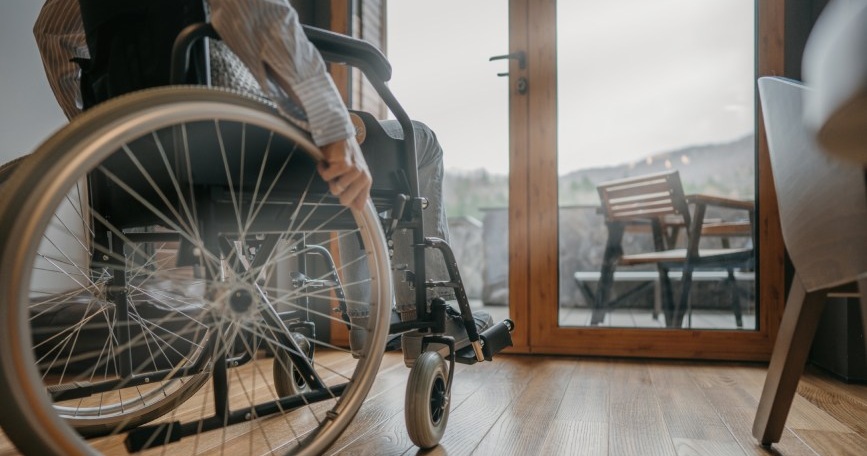 Persona usuaria de silla de ruedas desplazándose por el interior de una vivienda accesible, símbolo de la autonomía personal y la eliminación de barreras arquitectónicas.