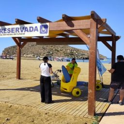 Zona accesible con silla anfibia en una playa de Mazarrón Zona reservada accesible con pasarela de madera y silla anfibia en una playa de Mazarrón.