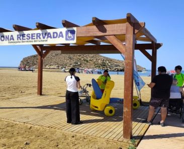 Zona reservada accesible con pasarela de madera y silla anfibia en una playa de Mazarrón.