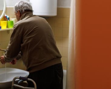 Soledad no deseada y personas mayores con discapacidad Persona mayor con un andador realizando una actividad cotidiana en su hogar.
