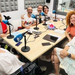 COCEMFE Alicante en Radio Altea: inclusión y accesibilidad Ocho personas, entre ellas una mujer usuaria de silla de ruedas, reunidas alrededor de una mesa con micrófonos en el estudio de Radio Altea.