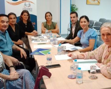Ocho personas reunidas alrededor de una mesa en la sede de COCEMFE Badajoz para abordar mejoras en la accesibilidad sanitaria.