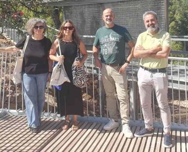 Dos mujeres y dos hombres posan sobre una pasarela con barandillas metálicas en el Poblat de Sant Josep, en la Vall d’Uixó.