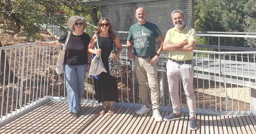 Dos mujeres y dos hombres posan sobre una pasarela con barandillas metálicas en el Poblat de Sant Josep, en la Vall d’Uixó.