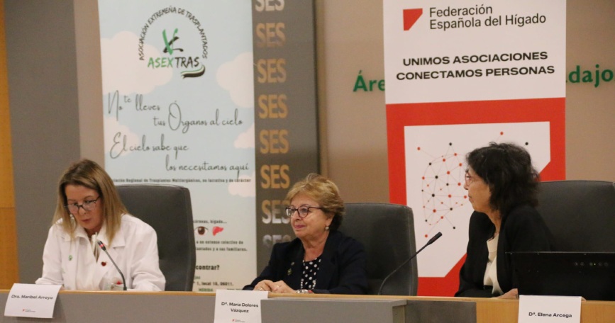Tres mujeres participan en una mesa de las Jornadas Formativas de la Federación Española del Hígado, con carteles de la FEH y ASEXTRAS al fondo.