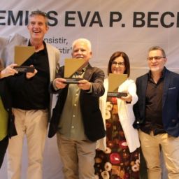 Cinco personas posan ante el cartel de los Premios Eva P. Bech durante la ceremonia de entrega en Badajoz. Tres muestran sus galardones.