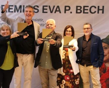 Cinco personas posan ante el cartel de los Premios Eva P. Bech durante la ceremonia de entrega en Badajoz. Tres muestran sus galardones.